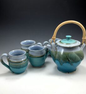Turquoise teapot and set of four matching mugs